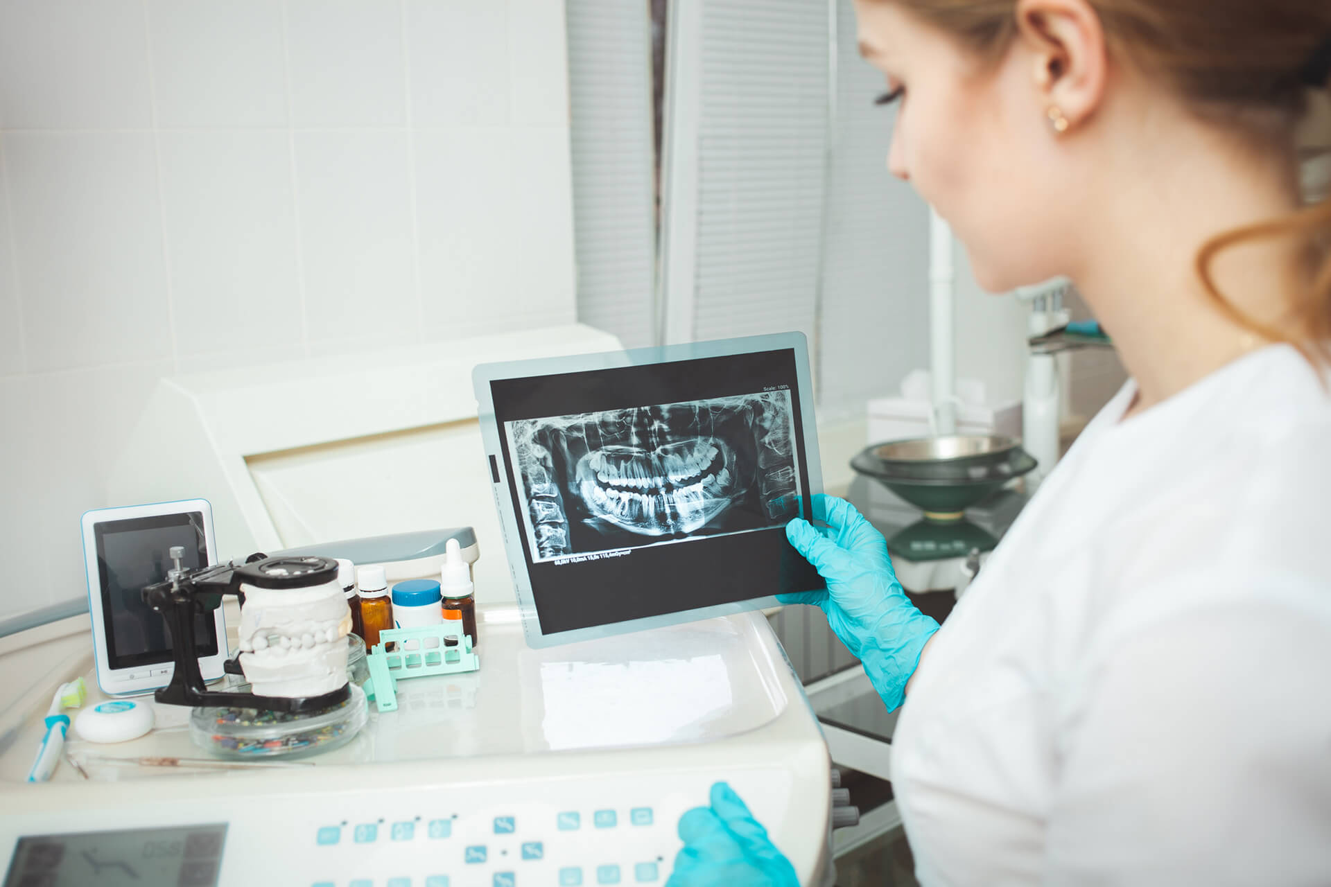 Stomatolog analizujący panoramiczne zdjęcie RTG zębów na tablecie podczas diagnostyki przed zabiegiem chirurgii stomatologicznej w Nowym Mieście nad Pilicą