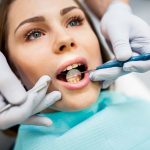 Stomatolog badający dziąsła i przyzębie pacjentki narzędziami dentystycznymi podczas wizyty periodontologicznej w Klinice Biały Kamień w Nowym Mieście nad Pilicą